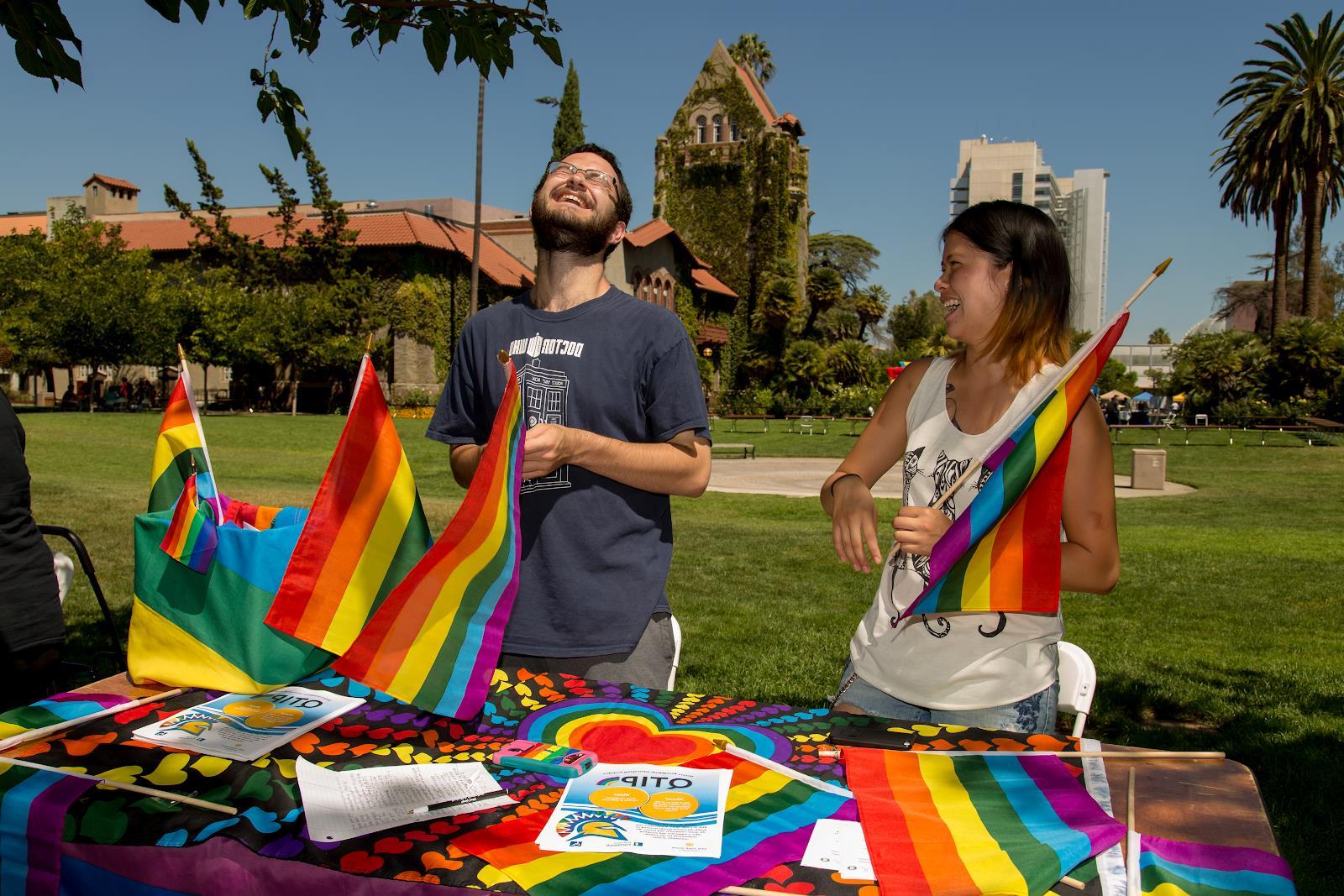 学生们举着彩虹旗，笑着为学生组织排队.